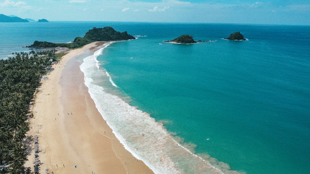 Aerial view of a stunning tropical beach with clear blue waters and lush islands.
