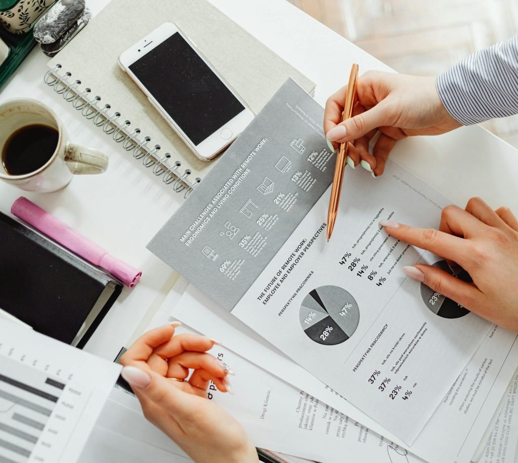 Team collaborating on financial documents with graphs and statistics in an office setting.